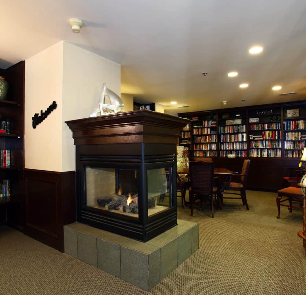 Library area with a fireplace at a senior living facility in Omaha, Nebraska.