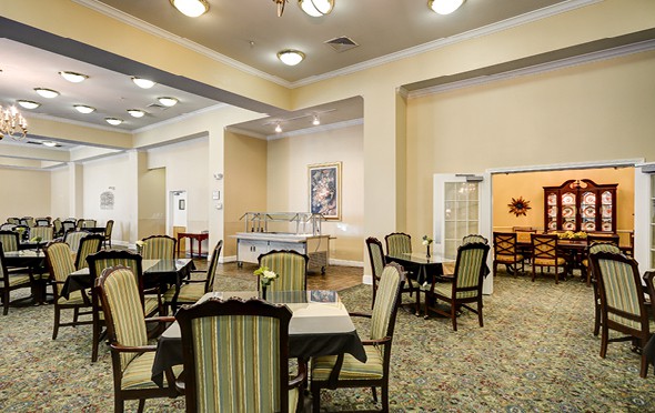 Large, spacious dining room with many tables and French doors leading to a private dining room in Plano, Texas.