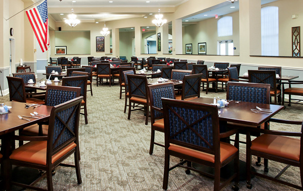 Bright, spacious dining room with many tables for 4 and an American flag in Richardson, Texas