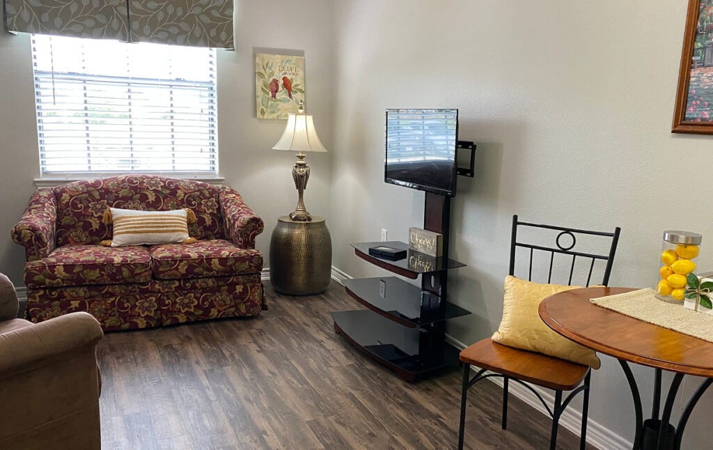 Senior apartment with a television, couch and chair at a senior living community in Lake Granbury, Texas.