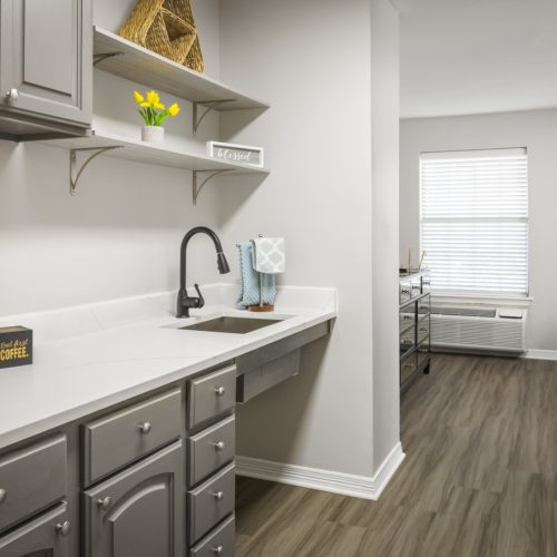 Senior apartment kitchenette with a sink and storage at a senior living community in Baytown, Texas