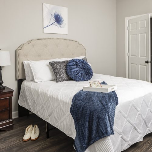 Apartment bedroom with a large bed, side table and closet