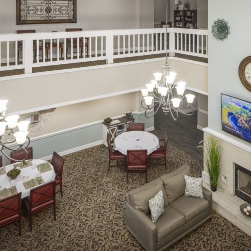 Lounge area at a senior living community in Conroe, Texas with couches, a television and fireplace
