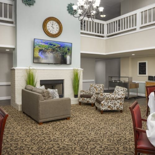 Lounge area with a fireplace, couches, tables and chairs