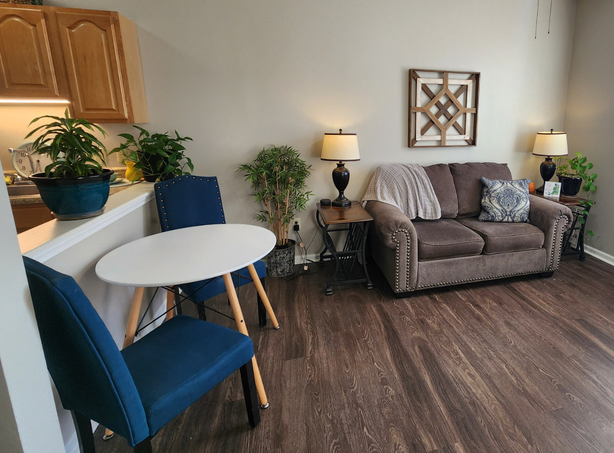 Apartment living room with a couch and small seating area near the kitchen