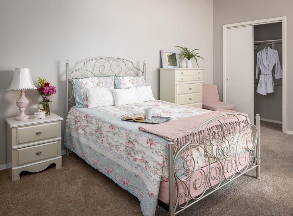The Wellington at North Richland Hills Studio apartment with queen bed, side table, closet and window