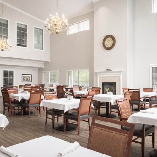 A spacious dining area with flower centerpieces on all tables and a fireplace in North Richland Hills, Texas.