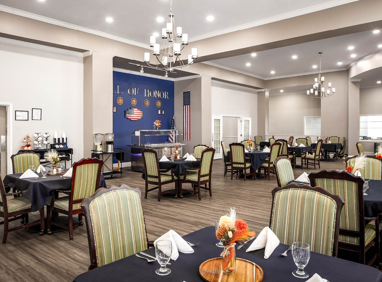 Large, spacious dining room with many tables and French doors leading to a private dining room in Plano, Texas