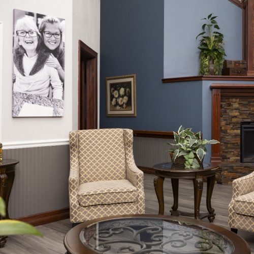 Lobby area with a fireplace, receptionist office and seating for seniors