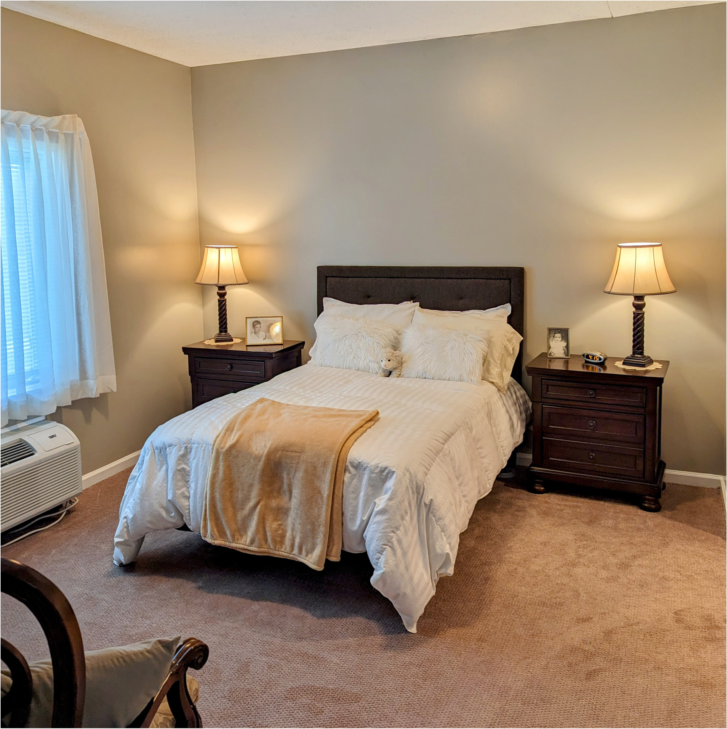 senior living apartment bedroom with a bed, two dressers and a window at Autumn Glen in Greencastle, IN