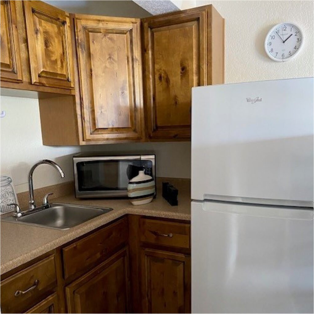 senior living apartment kitchen with a full-sized refrigerator, sink, microwave and cabinets in Cottonwood, Arizona