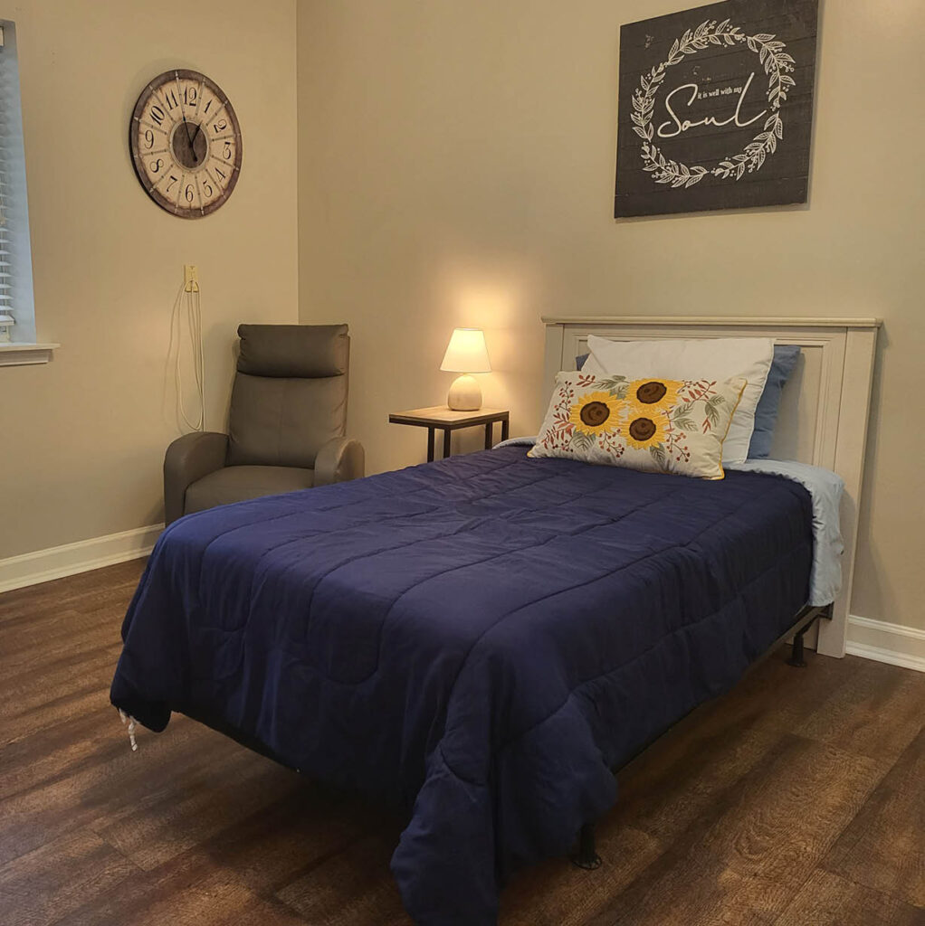 Model studio apartment featuring a large bed and window in Pensacola, Florida.