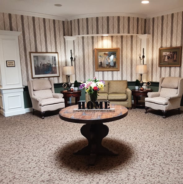 A welcoming lobby with comfortable seating and a table in the center with a “HOME” sign on it in Hamilton, Ohio.