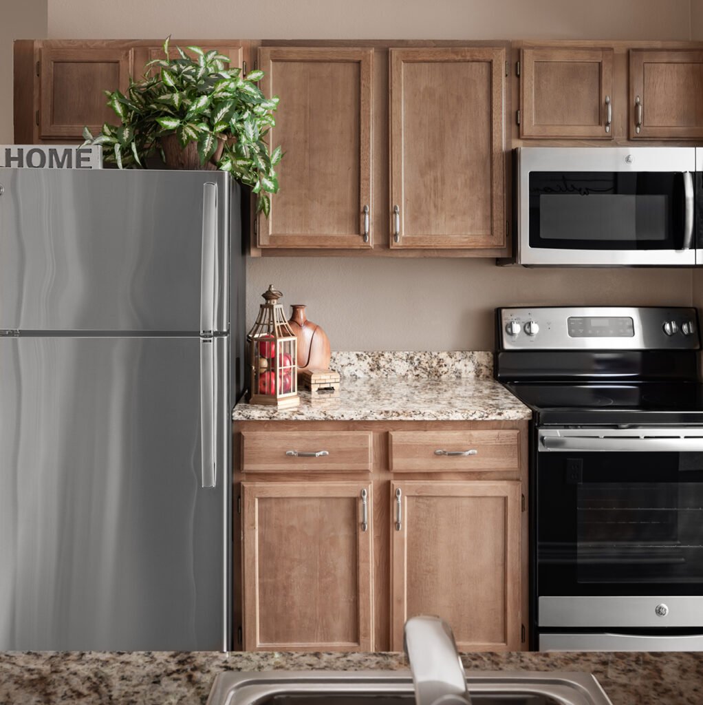 A model apartment kitchenette complete with full-size fridge, microwave and oven range at The Remington at Valley Ranch.
