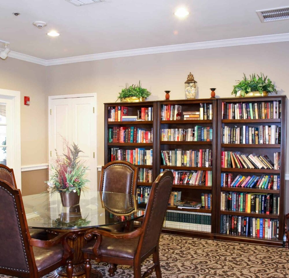 Library inside a senior living community in Stephenville, Texas with a table and chairs and shelves of books.