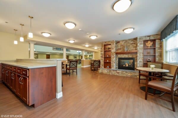 A lounge area with fireplace and sitting area at the Harrison, a senior living community in Indianapolis, Indiana.