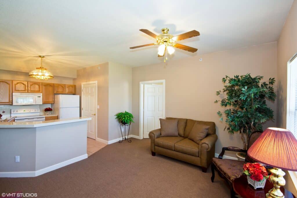Senior apartment kitchen and living room at a senior living community in Conroe, Texas.