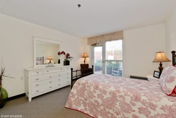 Model bedroom with bed and dresser at senior living facility in Virginia Beach, Virginia.