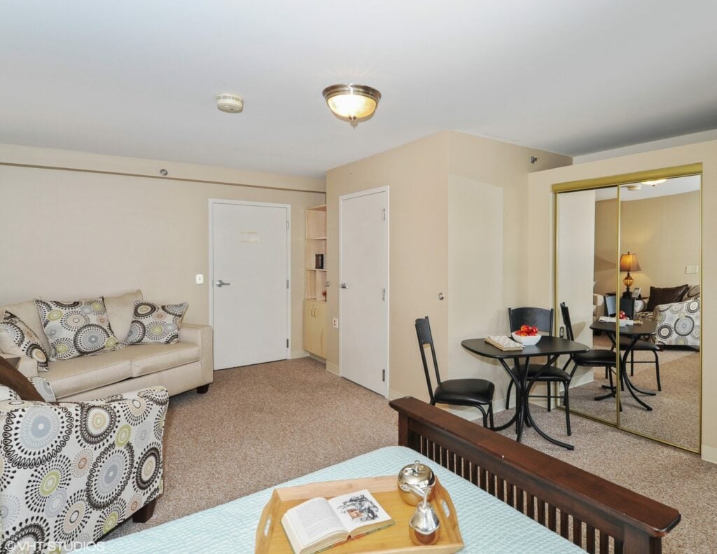 Model studio apartment with bed, couch and table at a senior living community in Indianapolis, Indiana.