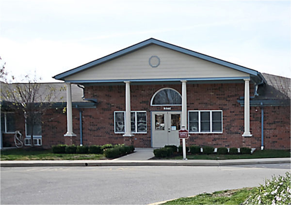 The entrance to a senior living community in Greenwood, Indiana with brick facade and white columns.