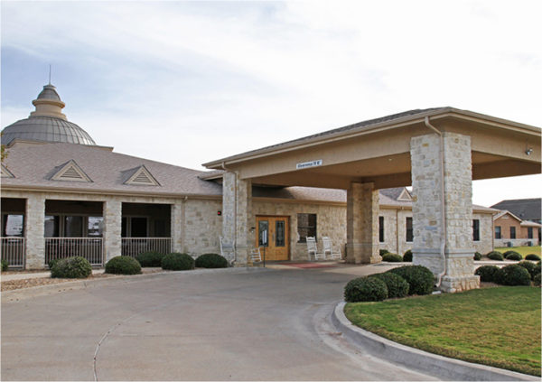 Exterior of senior living community in Granbury, Texas with stone facade.