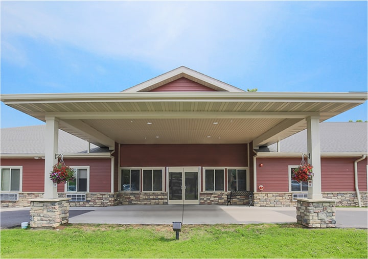 Front entrance of a senior living facility in Park Falls, Wisconsin with covered driveway.