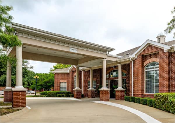 Front entrance of a senior living facility in Plano, Texas with covered driveway.