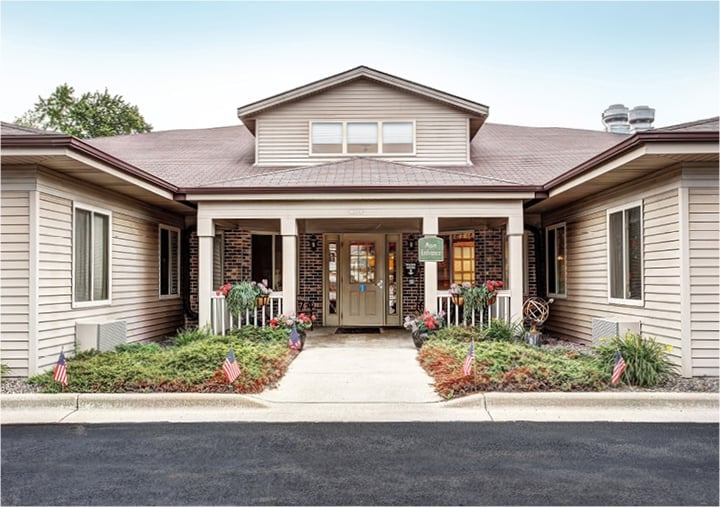 Front entrance of a senior living facility with lush landscaping in West Bend, Wisconsin.