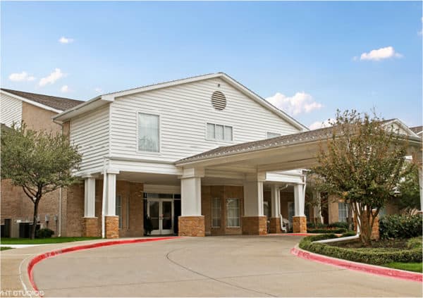 Front entrance of a senior living facility in North Richland Hills, Texas with covered circular driveway.