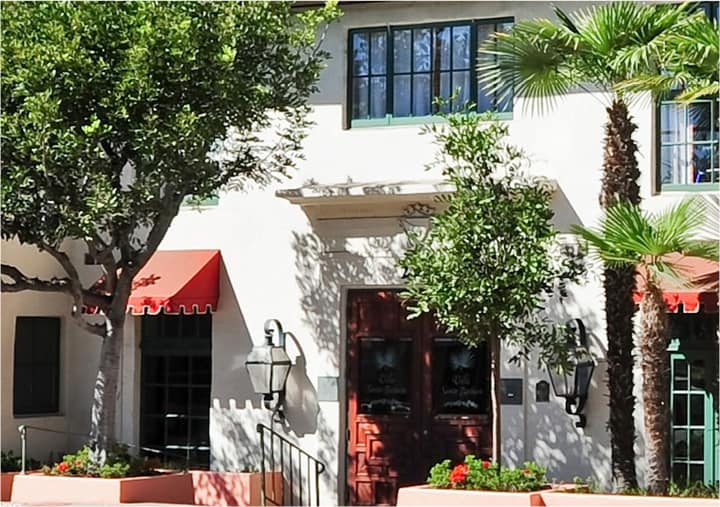 Front entrance of a senior living facility in Santa Barbara, California with a palm tree at the entrance.