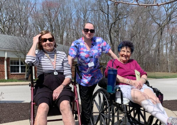 Two senior women spend time outdoors with a female caregiver at a senior living community in Lambertville, Michigan