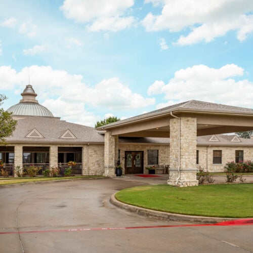 Courtyards at Lake Granbury front entrance. Exterior of senior living community in Granbury, Texas with stone facade.