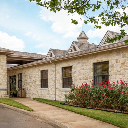 Courtyards at Lake Granbury front entrance. Exterior of senior living community in Granbury, Texas with stone facade.