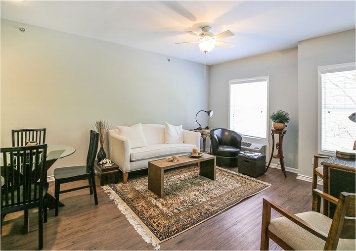 Interior of a resident apartment with a dining area and a large lounge area with sofa, coffee table and accent chairs in Ridgeland, Mississippi.