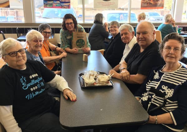 A group of residents gathered round a restaurant table on a scheduled outing in North Richland Hills, Texas.