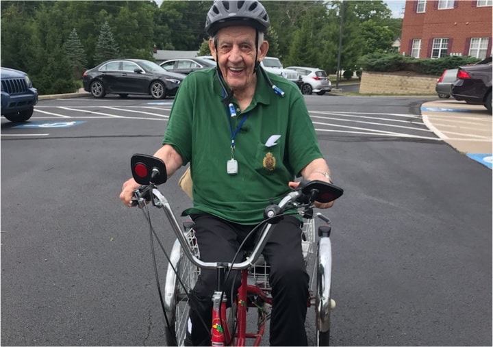 Senior man smiles while riding a three-wheeled bike in Macedonia, Ohio