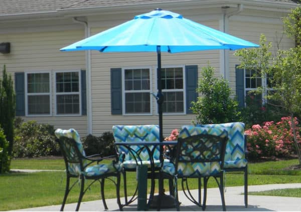 An umbrella covered dining set in a beautifully landscaped courtyard in Virginia Beach, Virginia.