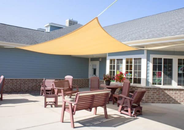A large patio with outdoor dining and a sunbrella in Wisconsin Rapids, Wisconsin.