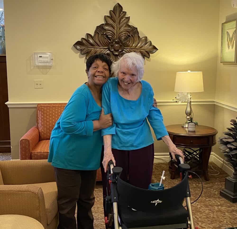 Two senior women smile while hugging at The Woodlands of Shaker Heights, a senior community in Shaker Heights, Ohio.