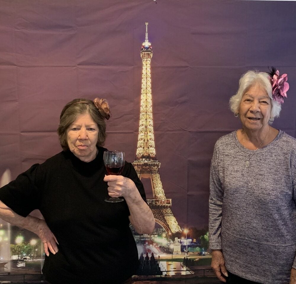 Senior ladies at a party with Paris decorations at a senior living community in Irving, Texas.