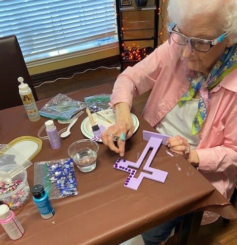 Senior woman doing a craft project at a senior living facility in Fort Worth, Texas.