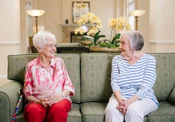 Two senior women smile at each other at a senior living community in Springfield, Missouri.
