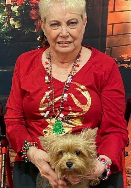 Senior woman smiles with her pet dog at a senior living facility in Fort Worth, Texas.