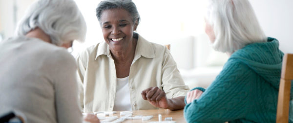 Senior women playing a game of dominos.