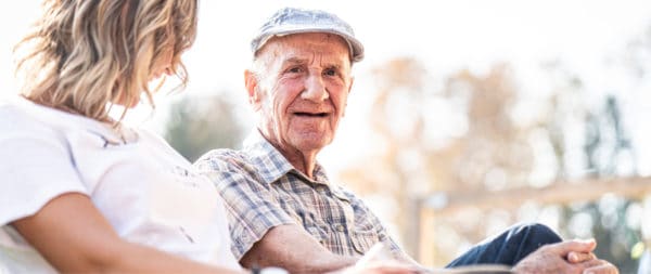 A man sitting on a bench talking about senior living with his daughter