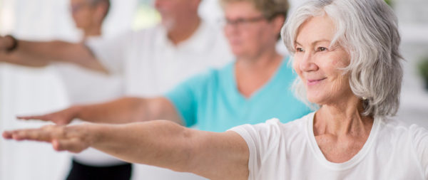 Senior woman holding a pose during a yoga class.