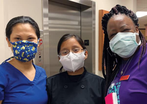 Three masked employees with smiling eyes.