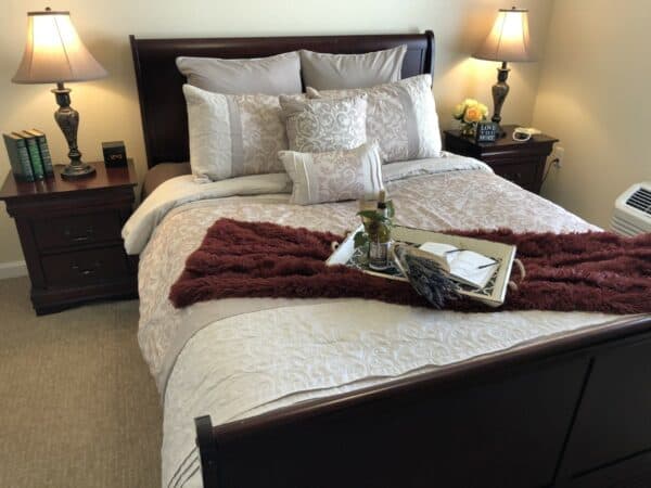 Independent living apartment at a senior living community in Dayton, Ohio with full size bed and two nightstands.