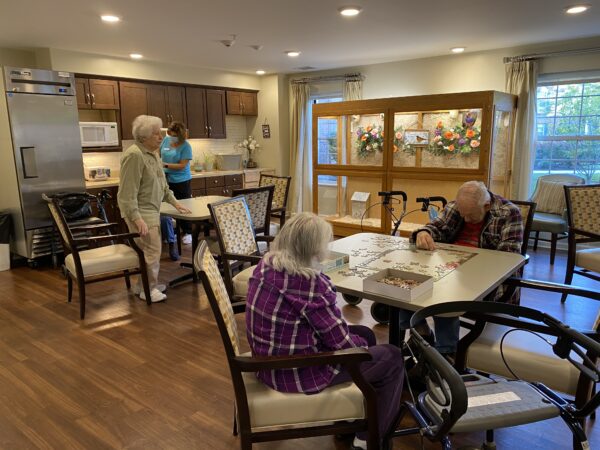 Two seniors do a puzzle together in a dining space at a senior living community in Fort Wayne, Indiana.