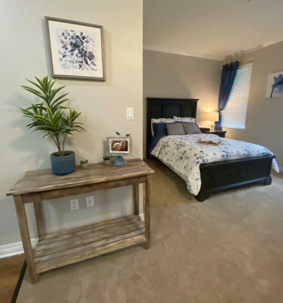 Senior apartment bedroom with bed and storage drawers in Arlington, Texas.